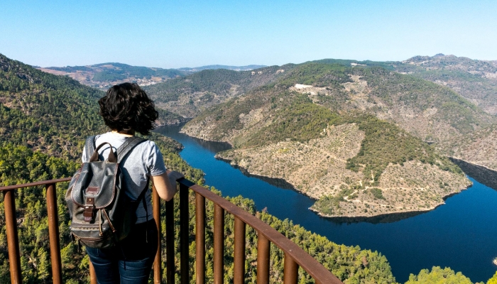 Woman enjoying the scenic beauty of the Douro River from Olhos do Tua viewpoint